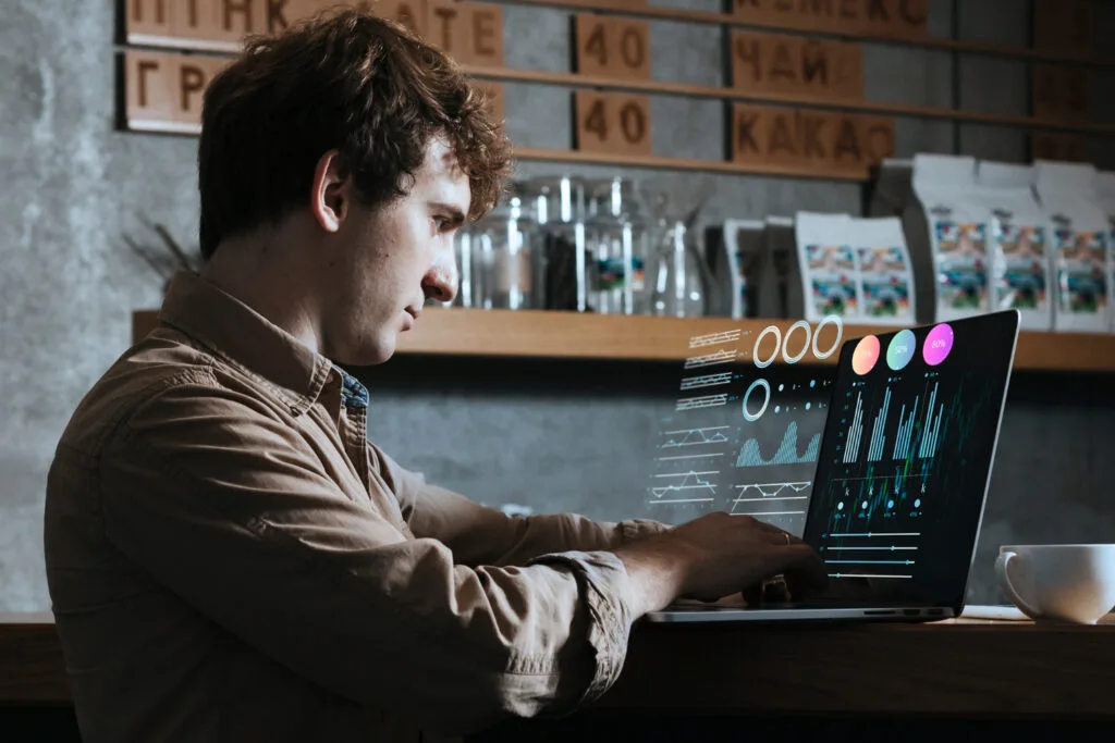 man working on laptop with 3d graphs