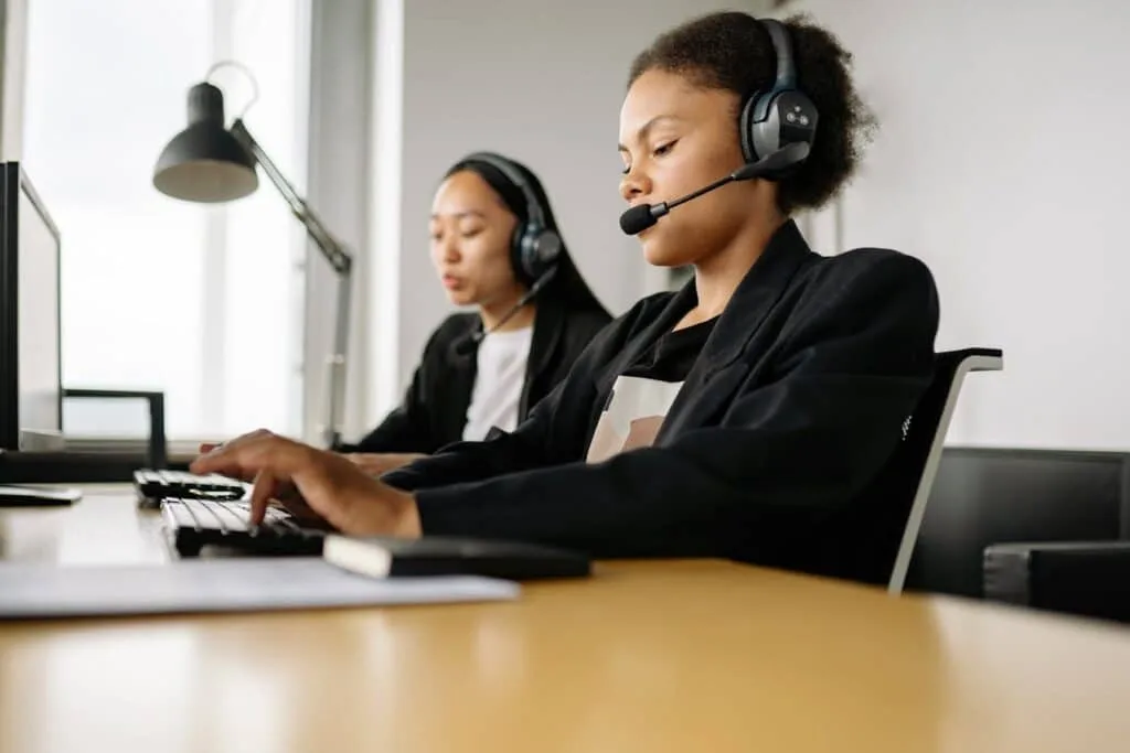 two women in a black suit working on a call center office
