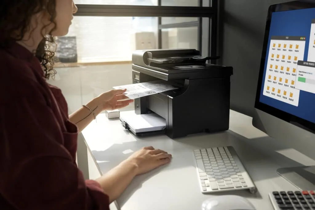 A woman sending a fax online using a computer.