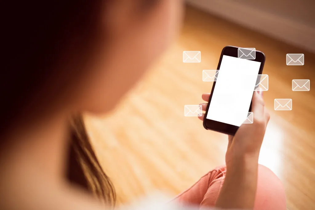 a woman holding mobile phone with SMS icon